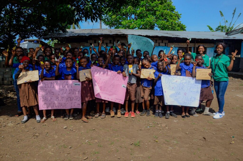 Pupils displaying peace messages with ASCOA facilitators