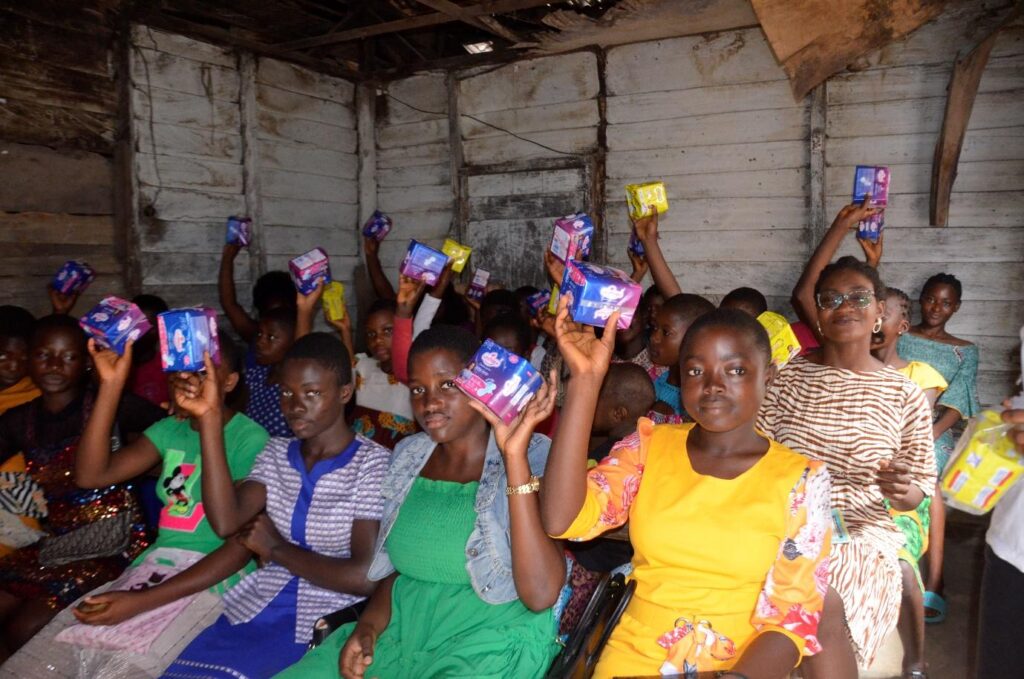 Participants holding sanitary products during ASCOA menstrual health education